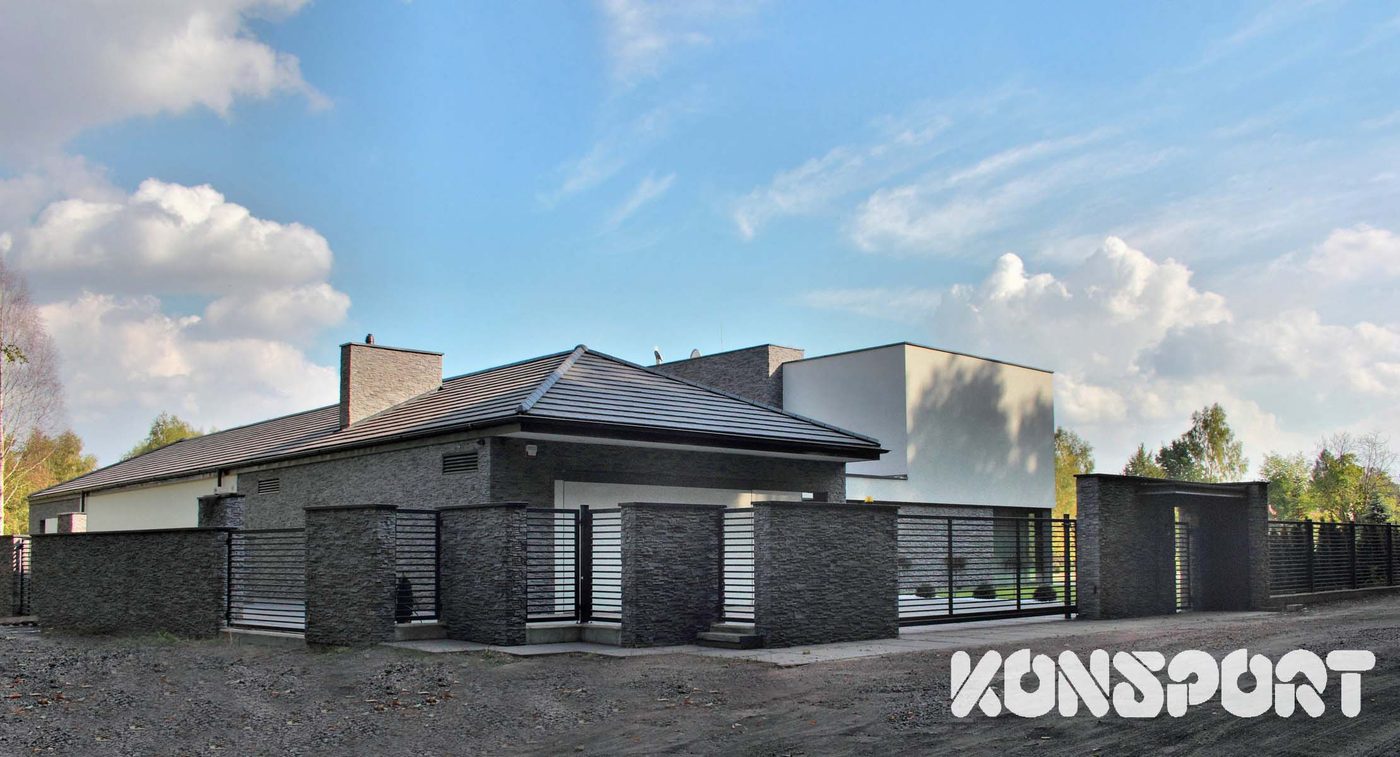 Konsport: Pełne przęsła między słupkami z ciemnego kamienia przy parterowym domu